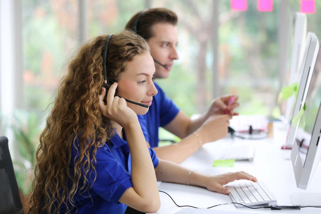 Female call center operator in headset working with laptop