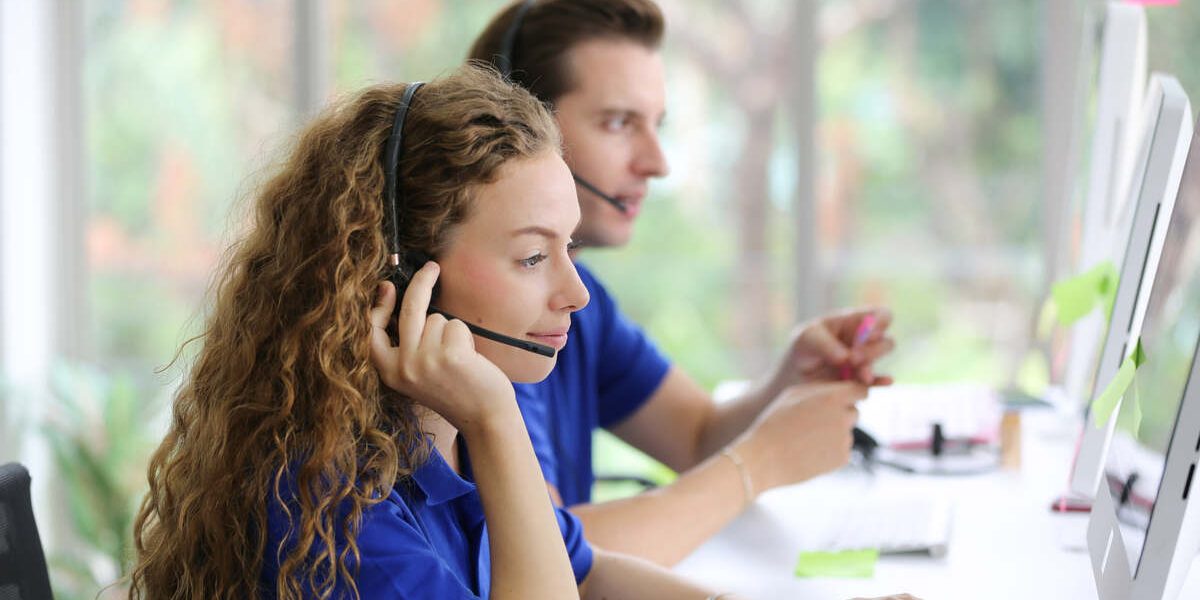 Female call center operator in headset working with laptop