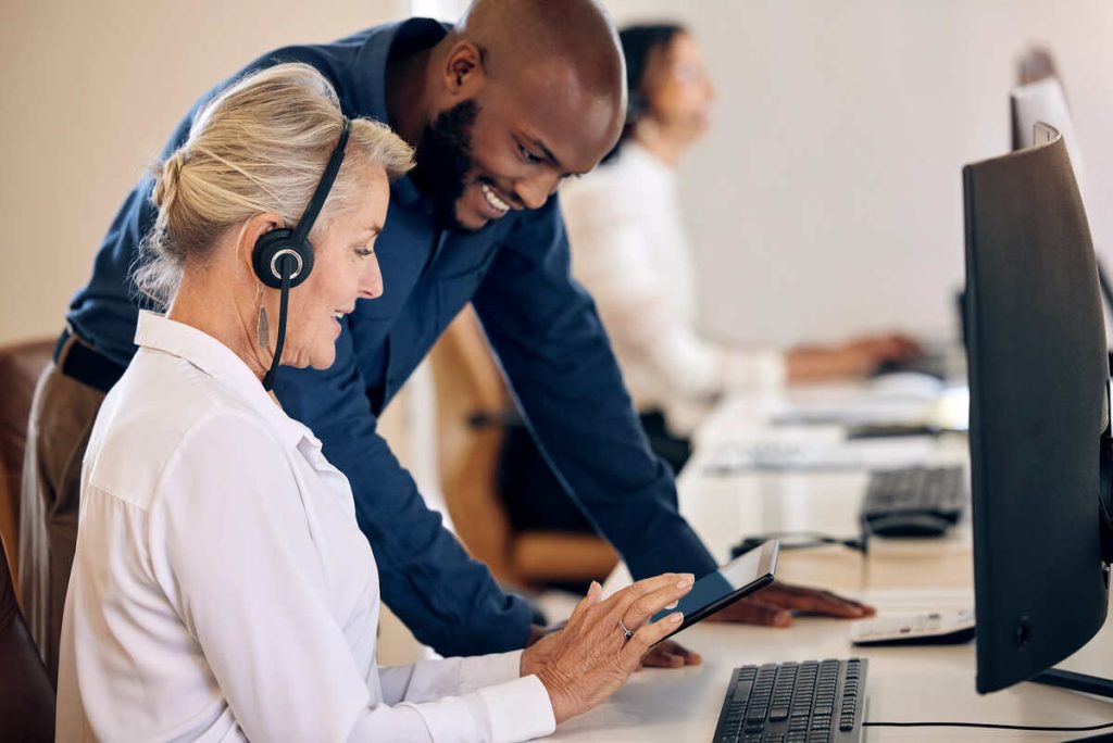 Shot of two call centre agents working together on a digital tablet in an office.