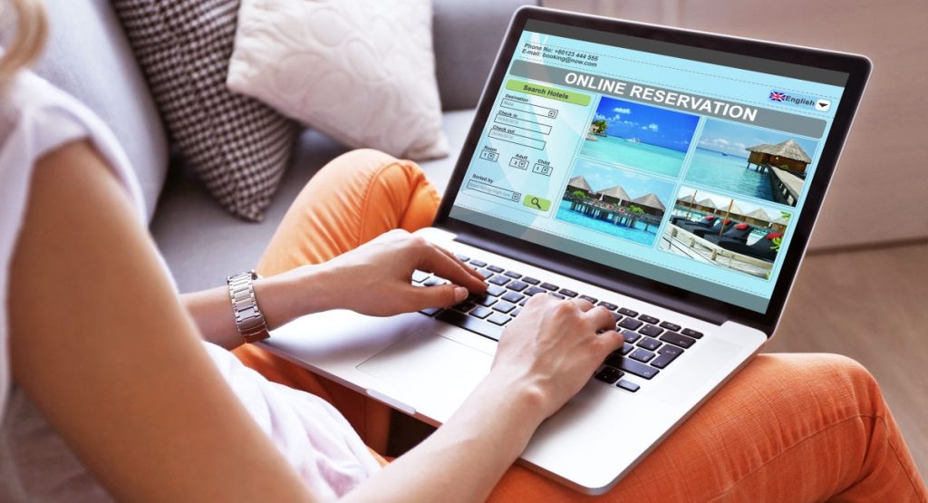 a person sitting on a couch using a laptop - travel bpo
