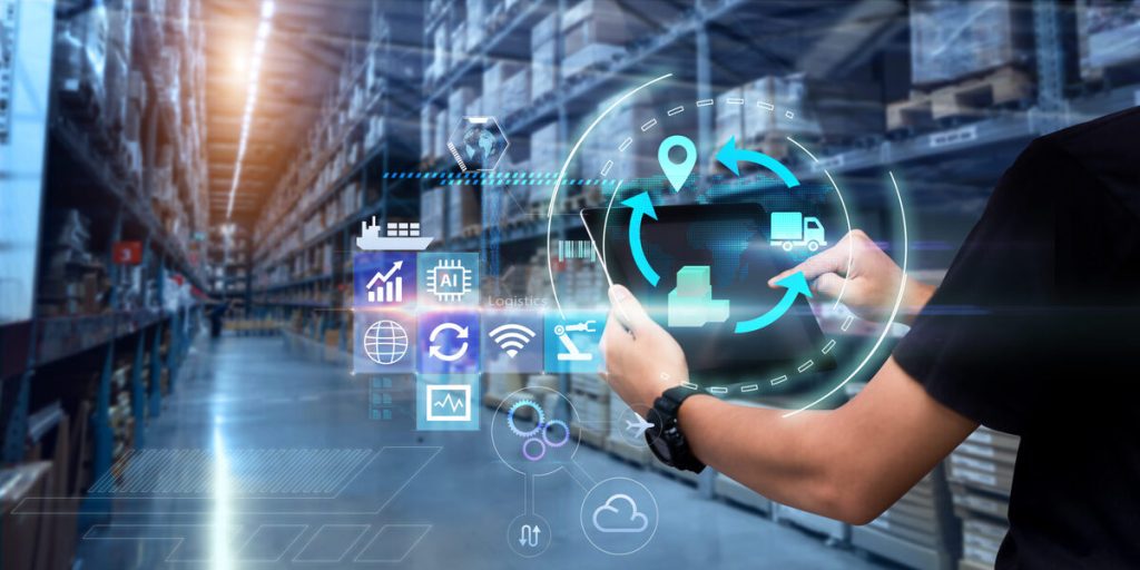 Man hands using tablet on blurred warehouse as background representing hero image for the blog about The Hidden ROI of Logistics Outsourcing Services